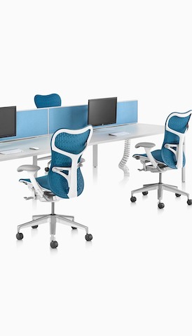 Una configuración de banco posterior con superficies de trabajo blancas de Layout Studio y sillas azules Mirra 2. Seleccione para ir a la página del producto Escritorios y espacios de trabajo.